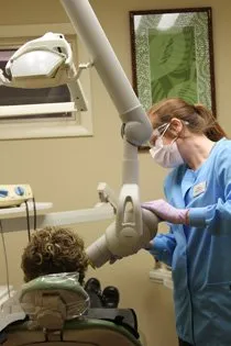 Dental staff member attending to a patient in an examination room