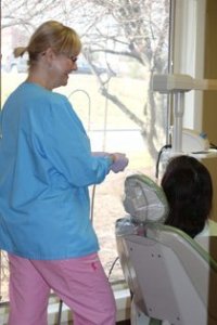 Dental staff member attending to a patient in an examination room