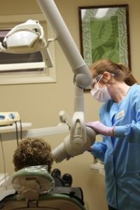 Dental staff member attending to a patient in an examination room